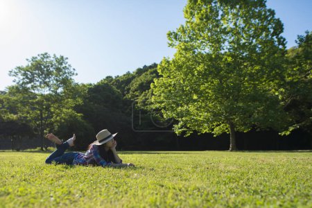 Téléchargez les photos : Femme allongée sur l'herbe dans un parc - en image libre de droit