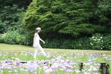Téléchargez les photos : Asiatique femme dans chapeau avec fleurs dans patk - en image libre de droit