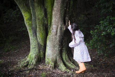 Photo for Girl touching the big tree - Royalty Free Image