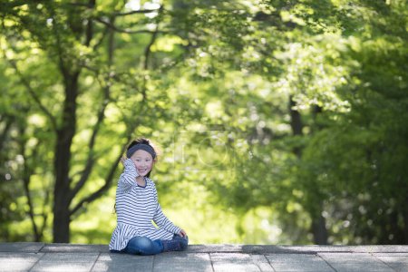 Photo for Little girl in green park - Royalty Free Image