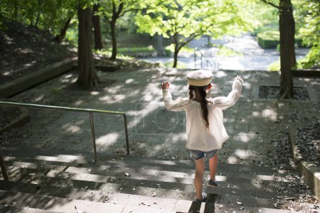 Kleines Mädchen auf der Parktreppe