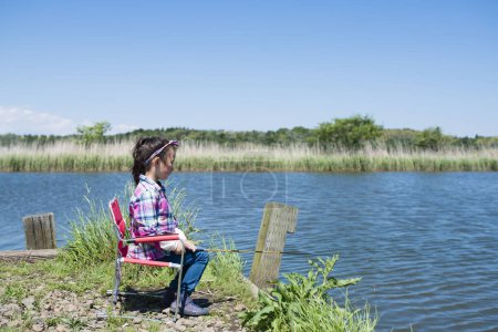 Photo for Little girl fishing on river or lake coast - Royalty Free Image