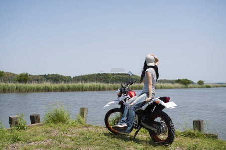 Téléchargez les photos : Femme en moto près du lac - en image libre de droit