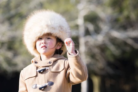 Téléchargez les photos : Petite fille portant un chapeau de fourrure trop grand - en image libre de droit
