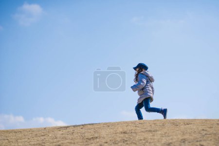 Téléchargez les photos : Courir Petite fille dans la journée ensoleillée - en image libre de droit