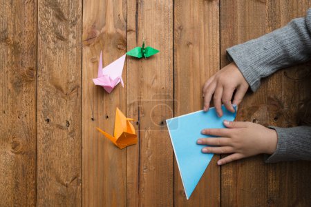 Photo for Child's hands to fold origami - Royalty Free Image