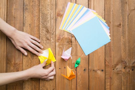 Photo for Woman's hands to fold origami - Royalty Free Image