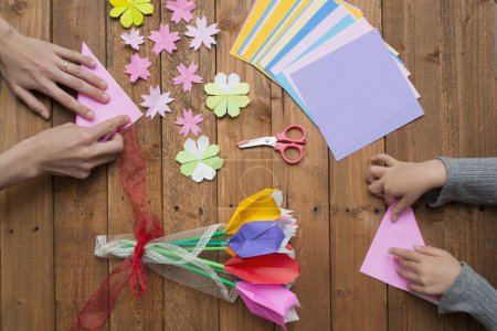 Photo for Parent and child hands playing with origami - Royalty Free Image