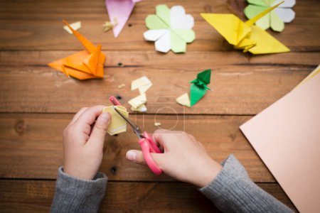 Téléchargez les photos : Les mains de l'enfant pour plier origami - en image libre de droit