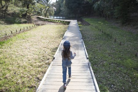 Téléchargez les photos : Petite fille courant sur la promenade - en image libre de droit