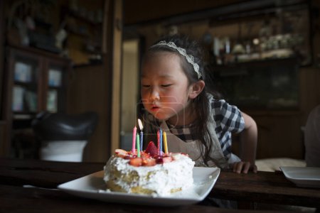 Téléchargez les photos : Petite fille soufflant les bougies de gâteau d'anniversaire - en image libre de droit