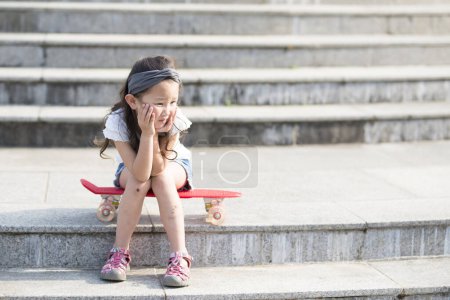 Foto de Chica asiática en monopatín en parque - Imagen libre de derechos