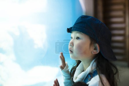 Téléchargez les photos : Petite fille asiatique regarder aquarium - en image libre de droit