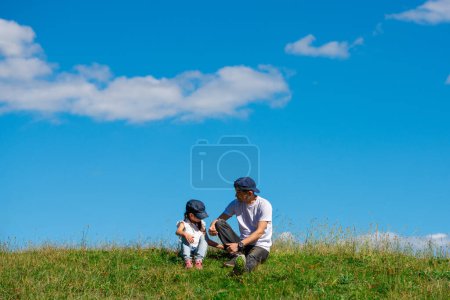 Foto de Padre e hija sentado en el prado - Imagen libre de derechos