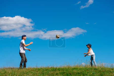 Téléchargez les photos : Père et fille jouant avec le ballon de football - en image libre de droit