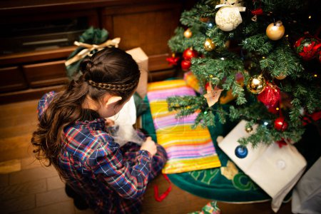 Téléchargez les photos : Fille ouvrant un cadeau de Noël - en image libre de droit