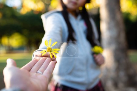 Téléchargez les photos : Parent et enfant remettant la fleur jaune - en image libre de droit