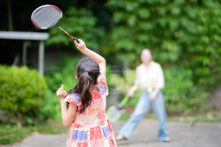Photo for Mother and daughter  playing badminton in summer - Royalty Free Image