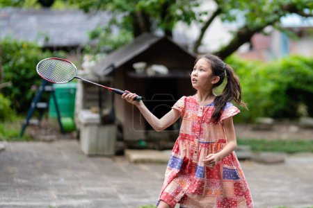 Photo for Girl playing badminton with a serious expression - Royalty Free Image
