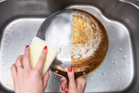 Woman's hand washing only half of a burnt frying pan