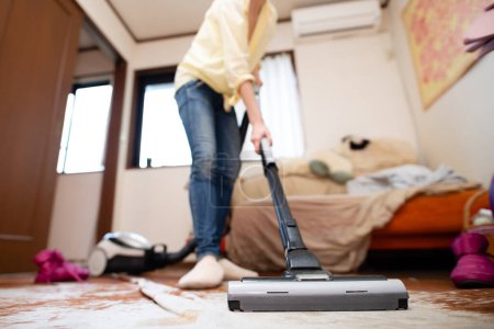 Photo for Woman cleaning the room with a vacuum cleaner - Royalty Free Image