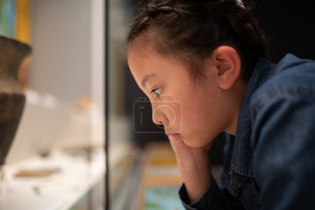 Téléchargez les photos : Enfant regardant quelque chose de sérieux dans le musée - en image libre de droit