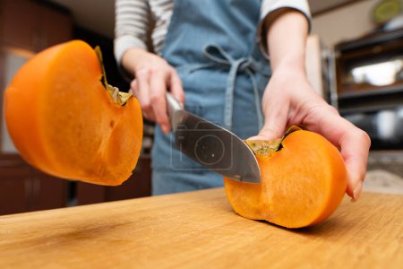 Photo for A woman's hands cutting a persimmon - Royalty Free Image