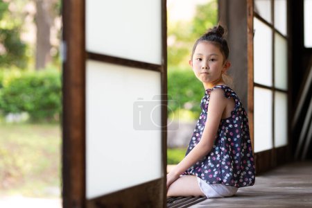 Foto de Chica sentada en una vieja casa japonesa - Imagen libre de derechos