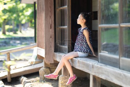 Foto de Chica sentada en una vieja casa japonesa - Imagen libre de derechos