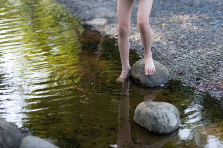 Téléchargez les photos : Les pieds d'un enfant jouant dans l'eau - en image libre de droit