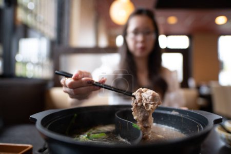 Foto de Mujer comiendo comida japonesa shabu-shabu - Imagen libre de derechos
