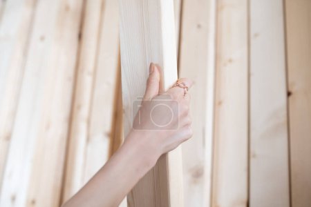 Téléchargez les photos : Main de femme choisissant une planche en bois - en image libre de droit