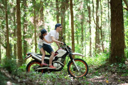 Foto de Padre e hija montando bicicleta todoterreno en carretera de montaña - Imagen libre de derechos