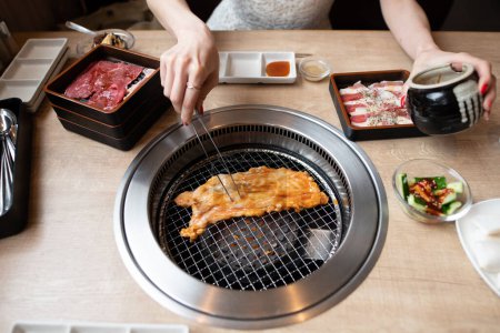 Une femme mange dans un restaurant japonais yakiniku