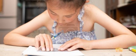 Foto de Una chica estudiando seriamente en casa - Imagen libre de derechos