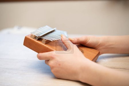 Photo for Hands of a woman playing kalimba - Royalty Free Image