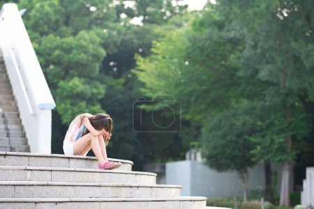 Photo for Girl sitting on stairs and crying - Royalty Free Image