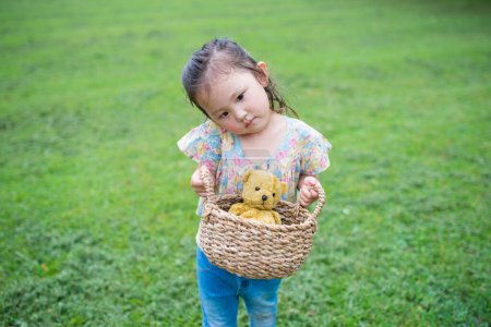 Photo for Little asian girl with teddy bear  in park. - Royalty Free Image
