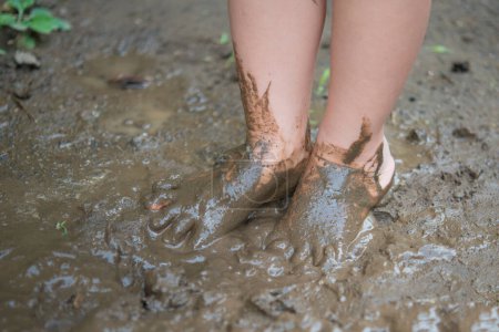 Petite fille jouant dans la boue
