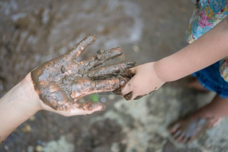 Petite fille jouant dans la boue
