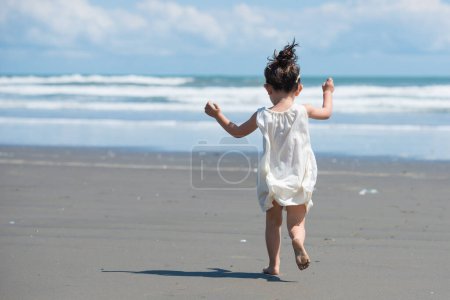 Téléchargez les photos : Petite fille courir sur la plage - en image libre de droit