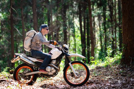 A man riding an off road motorcycle on a mountain road  