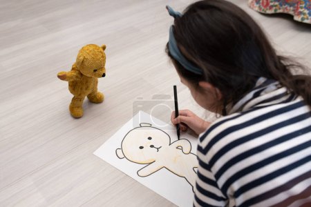 Foto de Una chica dibujando un dibujo de oso de peluche - Imagen libre de derechos