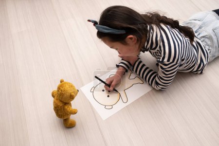 Photo for A girl drawing a picture of teddy bear - Royalty Free Image