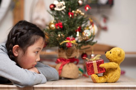 Foto de Chica recibiendo un regalo de Navidad de un oso de peluche - Imagen libre de derechos