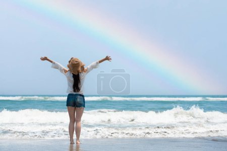 Photo for Woman open arms on rainbow beach - Royalty Free Image