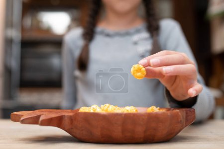 Photo for Child eating popcorn at home - Royalty Free Image