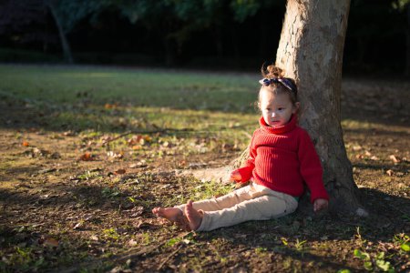 Photo for Girl sitting in the shade of a tree - Royalty Free Image