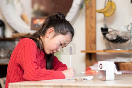 Photo for Girl doing homework at home - Royalty Free Image
