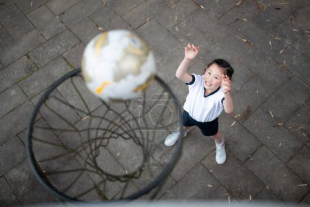 Photo for Child in gym clothes playing basketball - Royalty Free Image